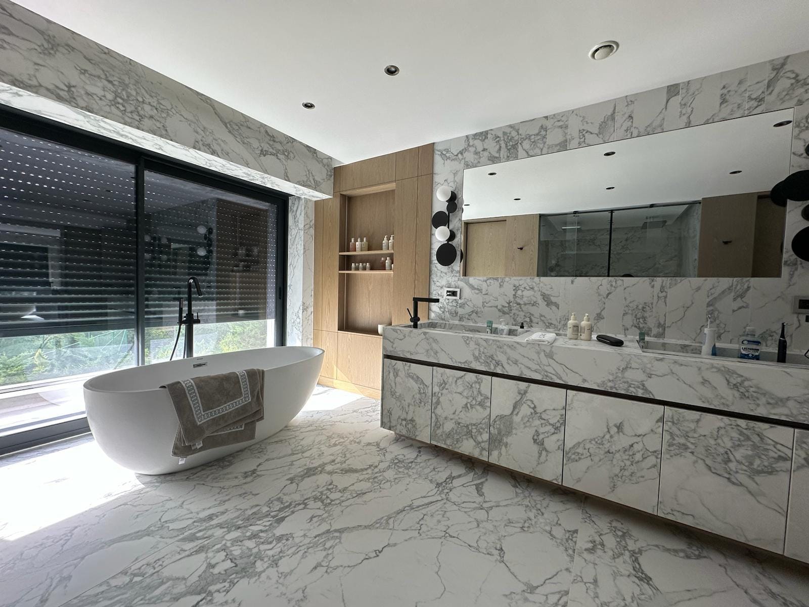 Gri damarlı Laminam yüzeylerle lavabo, dolap önleri, duvar ve zeminin bir arada görüldüğü banyo