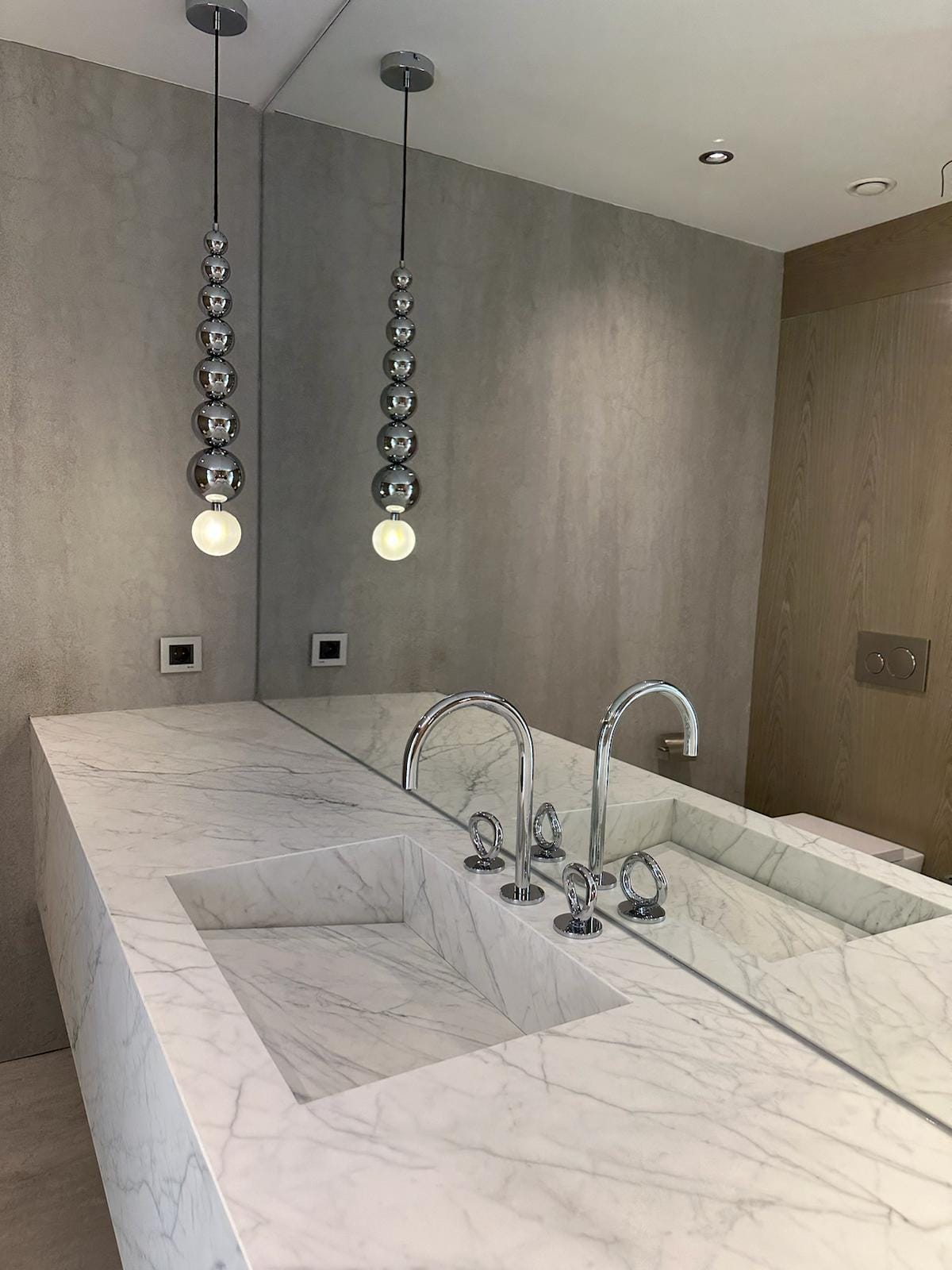 Açık damarlı porselen lavabo haznesi, tezgâhı ve krom armatürlerin yakın görünümü